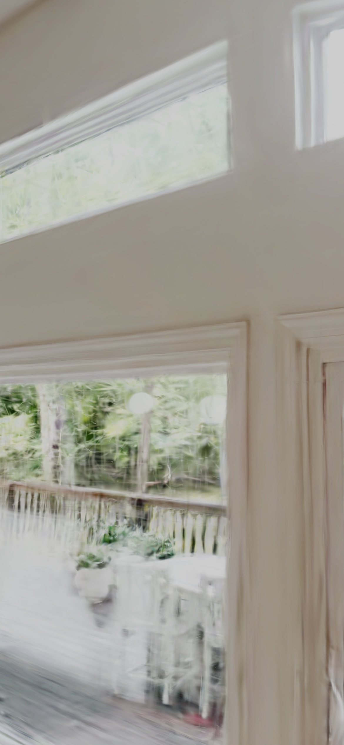 Photoreal 3D reconstruction of a bright living room window wall with a wooded deck outside, captured on an iPhone